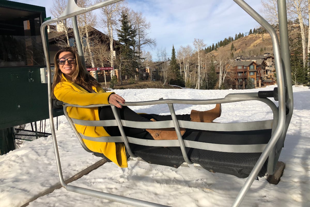 woman in yellow jacket riding a ski chairlift